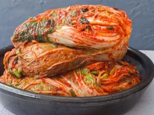 Rödfermenterad kimchi i lager i en svart skål
